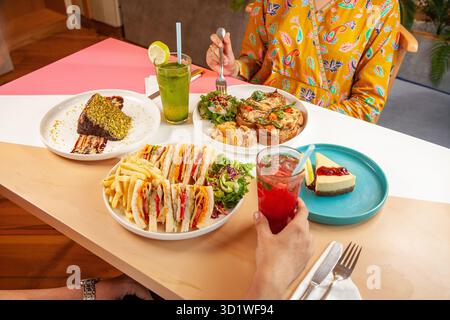 Male and Female friends enjoying having a meal in a restaurant cafe. Stock Photo