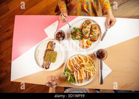 Male and Female friends enjoying having a meal in a restaurant cafe. Stock Photo