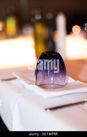 Blue Glass Upside Down on White Tablecloth Stock Photo