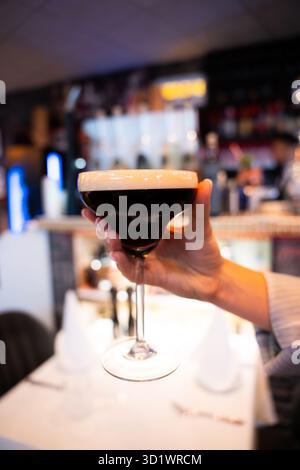 Hand Holding Espresso Martini in a Bar Stock Photo