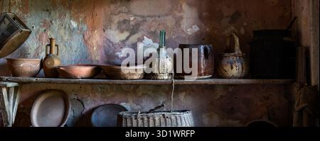 Vintage Rustic Kitchen Shelf with Antique Ceramic Pottery and Earthenware Vessels in Abandoned Mediterranean Farmhouse Stock Photo