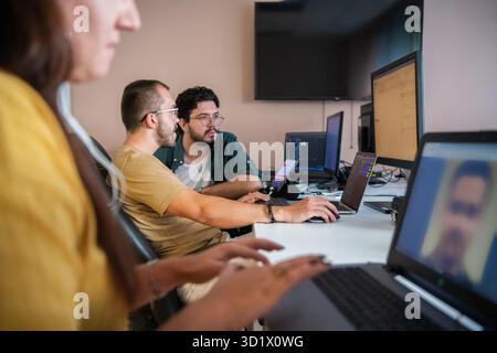 Top view of programmer diligently testing smartphone applications while sitting in their office. Stock Photo