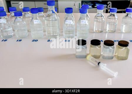 Laboratory equipment. Laboratory storage bottles with blue polypropylene cap and plastic bottles on white table. Stock Photo