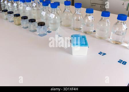 Laboratory equipment. Laboratory storage bottles with blue polypropylene cap and plastic bottles on white table. Stock Photo