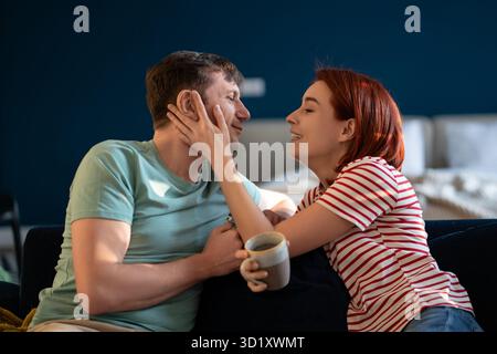 Happy middle aged family couple enjoying each other, woman touching man's cheek looking in his eyes. Stock Photo