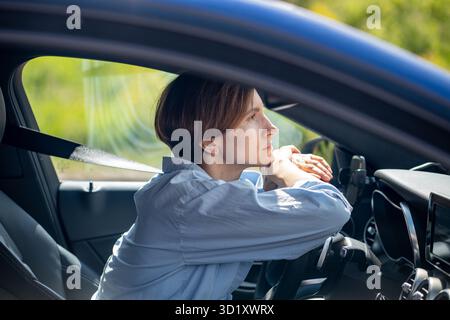 Pensive serious woman standing in traffic jam waiting driving car looking ahead. Stock Photo