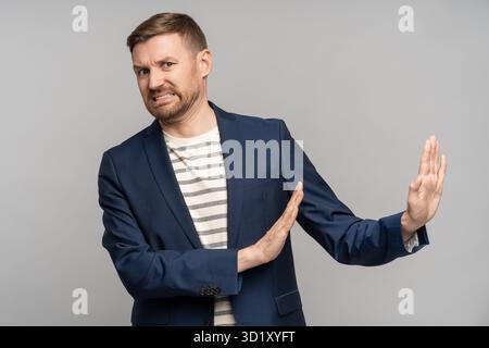 Man with disgust on face pushes negative space away from himself, moving away problems isolated Stock Photo