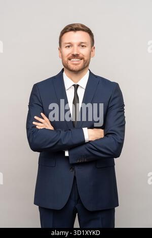 Portrait of happy successful confident businessman in suit with crossed arms on chest isolated Stock Photo