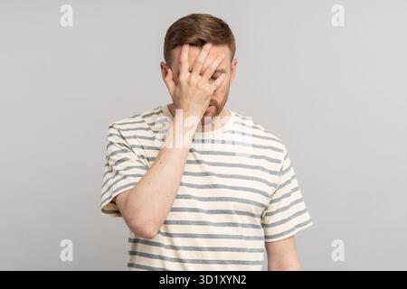 Disappointed stressed middle aged male making facepalm gesture with hand blaming himself for mistake Stock Photo