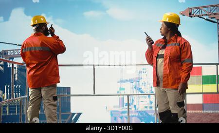 Drilling barge engineers use two way radio to communicate with logistics crew, monitoring systems. Offshore platform team talking in walkie talkie, controlling operation, Stock Photo