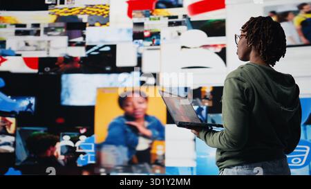 Smiling woman using laptop satisfied by access to video recommendations delivered instantly. Joyful user has fun in digital era enabling unlimited streaming, looking at clips on notebook, camera A Stock Photo