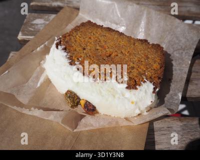 Carrot cake with cream cheese frosting on wooden table in New York cafe style setting Stock Photo