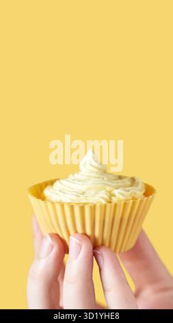 Yellow monochrome bakery. Sustainable cupcake cup. Hold in hand. Gold maffin cream. Trendy colourful desert. Bright birthday gif Stock Photo