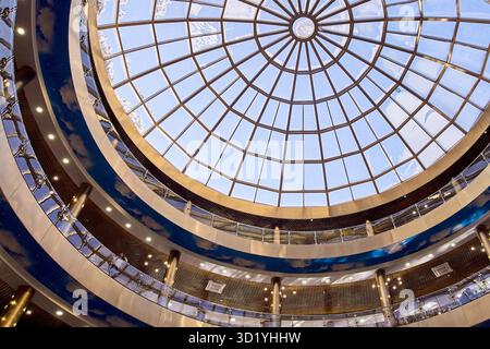 Interior skylight dome in modern shopping mall with elegant circular architecture and symmetrical glass ceiling design Stock Photo