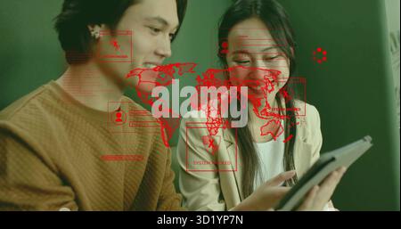 IT colleagues examining tablet screen in office with red map overlay and SYSTEM HACKED alert Stock Photo