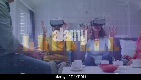 Using VR headsets friends raising hands on sofa in living room, with coffee table cups Stock Photo