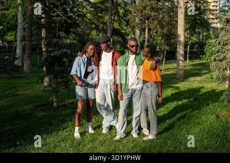 Young multiracial group of friends travel together, stand and posing for camera in park woods Stock Photo