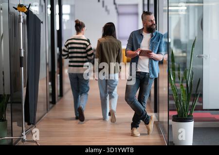 Senior bearded businessman, IT professional, trader, and crypto investor using a digital tablet in a modern coworking space. Tec Stock Photo