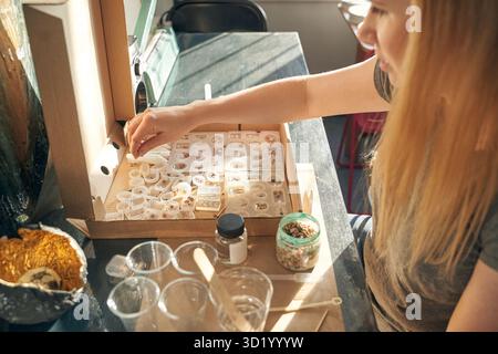 Young caucasian female engaged in science experiment with biological samples in laboratory setting. Stock Photo