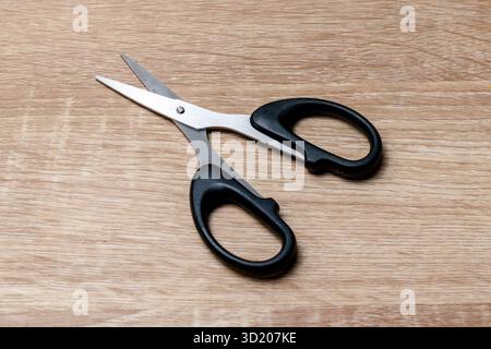A pair of scissors on a wooden table Stock Photo