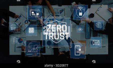 A high-angle view of a business meeting focused on cybersecurity. Professionals discuss the Zero Trust model, sharing insights on data protection and Stock Photo