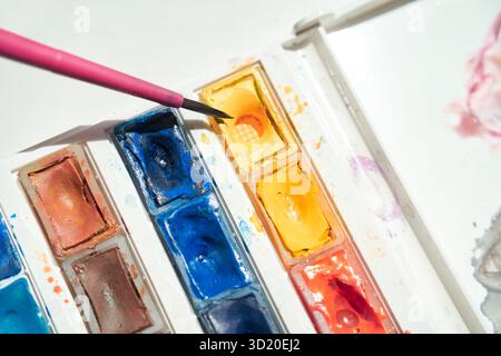 Close-up of watercolor paints and brush with vibrant yellow highlight Stock Photo