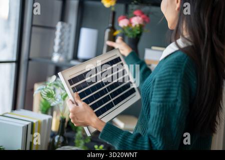Home owner install solar power systems in her house Asian Woman learning about sustainable technology Stock Photo