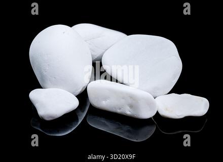 Smooth White Pebbles on Reflective Black Surface, Minimalist Still Life Stock Photo