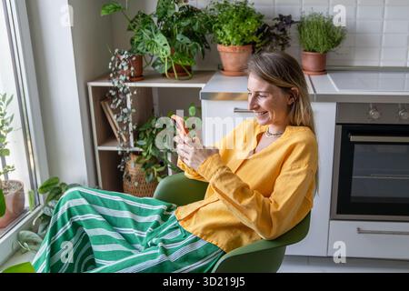 Overjoyed smiling positive woman with mobile phone, having video online call with friends, relatives Stock Photo