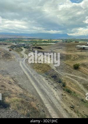 Rural landscape in Adjara, Georgia, features a winding dirt road through arid, hilly terrain Stock Photo