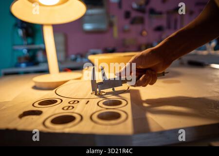 Carpenter use caliper on lamp blueprints in workshop. Handmade design, custom template measurements Stock Photo