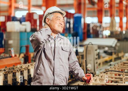 Senior worker tired exhausted muscle pain, Suffering neck pain from hard work in heavy industry Stock Photo