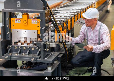 Technician engineer male machine service worker, professional work checking maintenance machine in plant factory Stock Photo