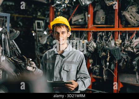 portrait young Caucasian technician worker working in heavy industry, looking camera happy smiling Stock Photo