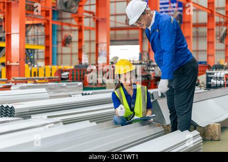women worker working in plant factory with senior supervisor training checking work order in metal sheet plant factory Stock Photo