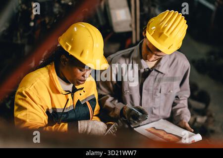 African women with engineer man staff worker working together heavy industry old used metal machine part stock inventory warehouse. Stock Photo