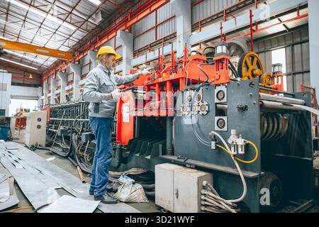 Professional senior Industrial worker in protective helmet and uniform service machinery in factory, expert engineer technician maintenance heavy mach Stock Photo