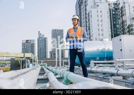 Professional engineer male technician worker service hotel boiler tank hot water supply pipe system. man safety checking maintenance pipeline heating Stock Photo