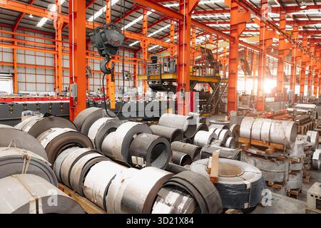 Metal sheet roll, metal roof manufacturing, steel sheet roll stock pile storage area warehouse in heavy industry manufacturing plant interior. Stock Photo