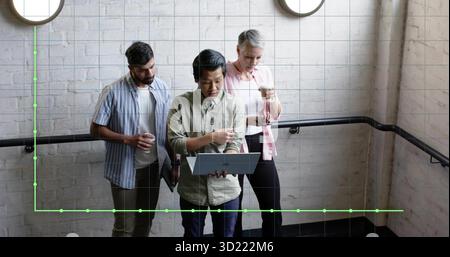 Leaning three professionals reviewing laptop on office stairwell with handrail, holding coffee cups Stock Photo
