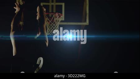 Basketball player in jersey 2 taking jump shot on court, with hoop, lens flare, copy space Stock Photo