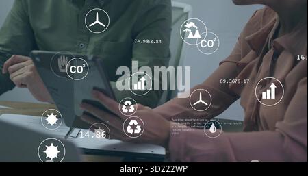 Analyzing CO? data on tablet, businessman and businesswoman pointing at screen in conference room Stock Photo