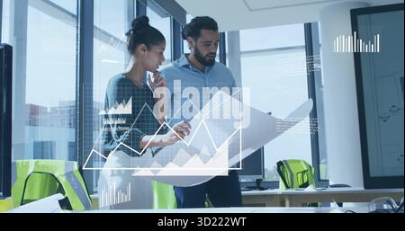 Two architects examining blueprint in modern office with mesh chairs, monitors and digital graphs Stock Photo