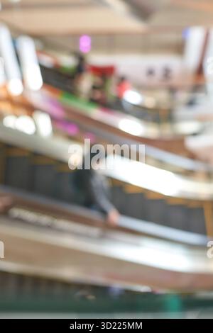 Blurred image of people on escalators in a shopping mall with abstract motion Stock Photo