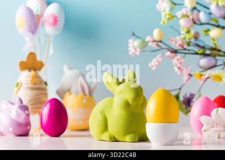 Festive Easter composition with Easter eggs and rabbits on a blue background. Stock Photo