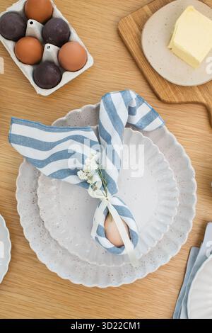 Easter egg wrapped in linen napkin in the shape of bunny with ears. Happy Easter Stock Photo