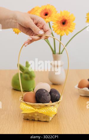 A woman holds a basket of Easter eggs. The concept of Happy Easter. Stock Photo