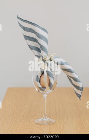 Easter egg wrapped in linen napkin in the shape of bunny with ears. Happy Easter Stock Photo