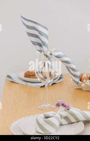 Easter egg wrapped in linen napkin in the shape of bunny with ears. Happy Easter Stock Photo