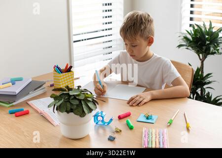 Cute boy doing school homework at home. Distance education. Online education. Stock Photo